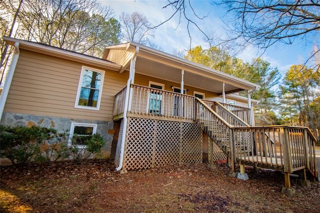 rear view of property featuring a wooden deck