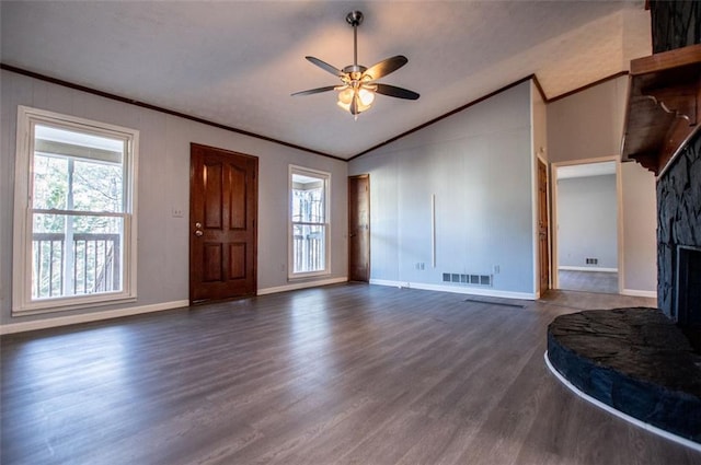 living room with vaulted ceiling, a stone fireplace, dark wood-type flooring, and crown molding