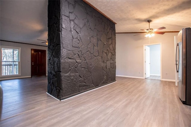 unfurnished room featuring crown molding, ceiling fan, light hardwood / wood-style floors, and a textured ceiling