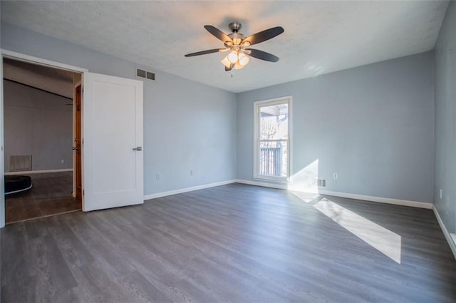 unfurnished bedroom featuring dark hardwood / wood-style flooring, a textured ceiling, and ceiling fan