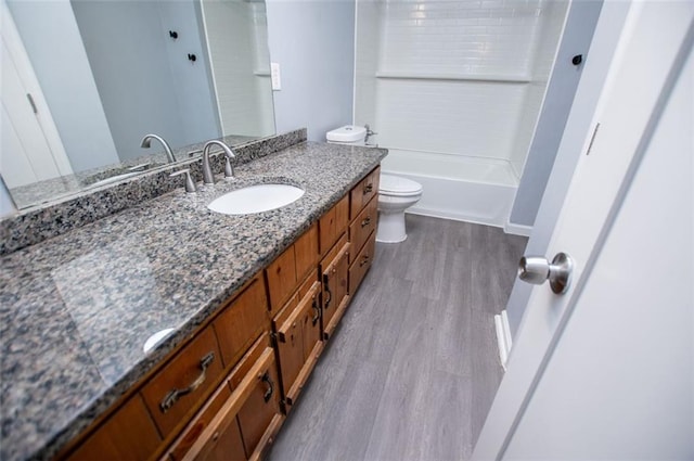 full bathroom with vanity, hardwood / wood-style flooring, toilet, and washtub / shower combination