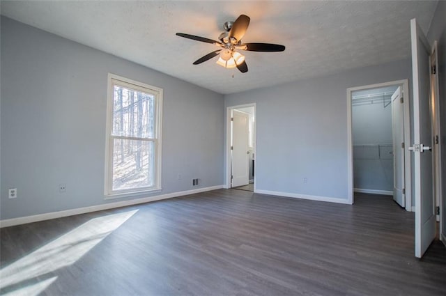 unfurnished bedroom featuring ceiling fan, dark hardwood / wood-style floors, and a textured ceiling