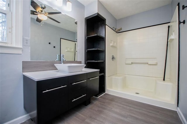 bathroom with hardwood / wood-style flooring, vanity, ceiling fan, and walk in shower