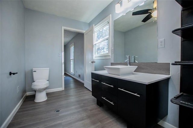 bathroom featuring ceiling fan, wood-type flooring, toilet, and vanity