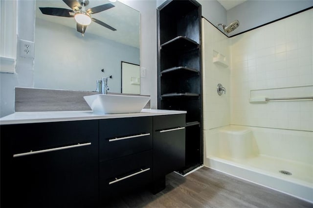 bathroom with vanity, hardwood / wood-style flooring, ceiling fan, and walk in shower