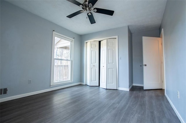 unfurnished bedroom with dark hardwood / wood-style floors, a closet, and ceiling fan