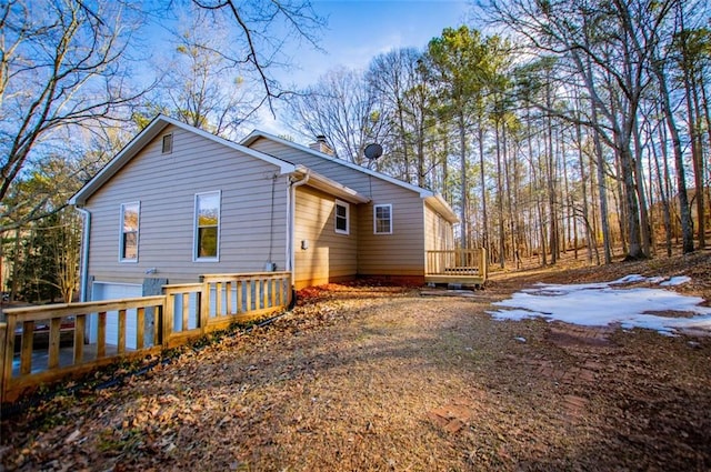 view of side of property featuring a garage and a deck