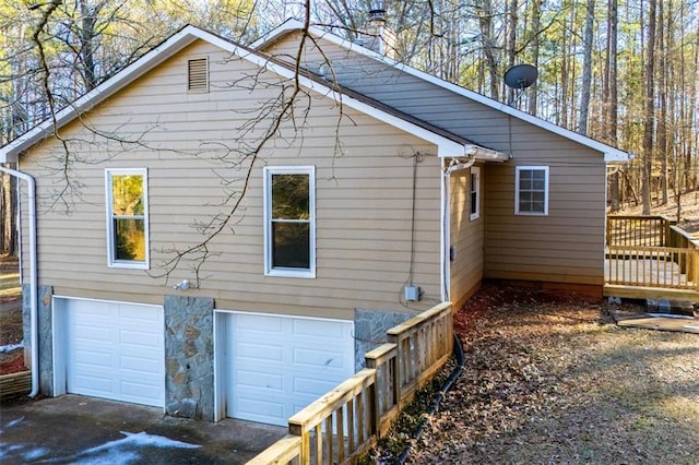 view of home's exterior featuring a wooden deck and a garage