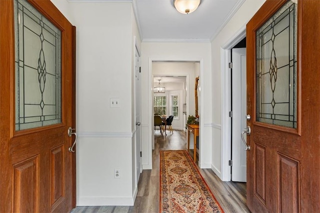 entrance foyer featuring crown molding, baseboards, and wood finished floors