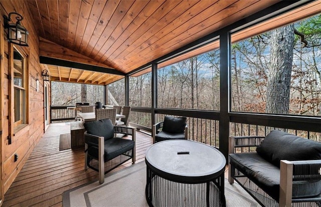 sunroom featuring lofted ceiling, an outdoor hangout area, and plenty of natural light