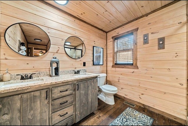 full bath featuring wooden walls, toilet, hardwood / wood-style flooring, double vanity, and wood ceiling