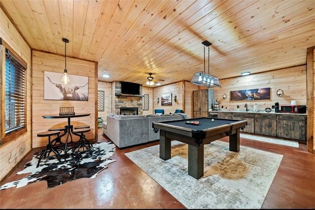 rec room with wood walls, wood ceiling, a fireplace, pool table, and ceiling fan