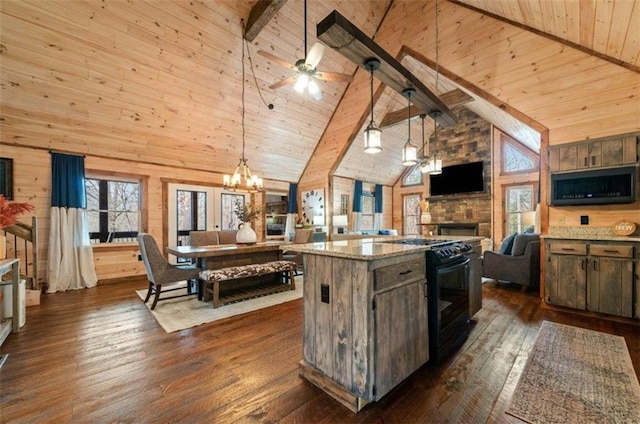 kitchen with gas stove, open floor plan, plenty of natural light, a stone fireplace, and high vaulted ceiling