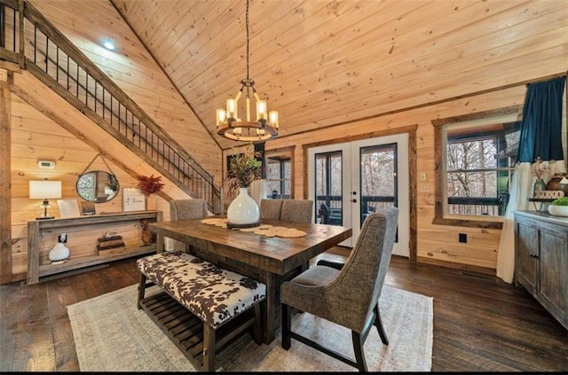 dining room featuring wood walls, french doors, wooden ceiling, a chandelier, and hardwood / wood-style floors