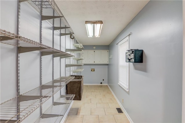 laundry room featuring washer hookup, light tile patterned floors, cabinet space, hookup for an electric dryer, and baseboards