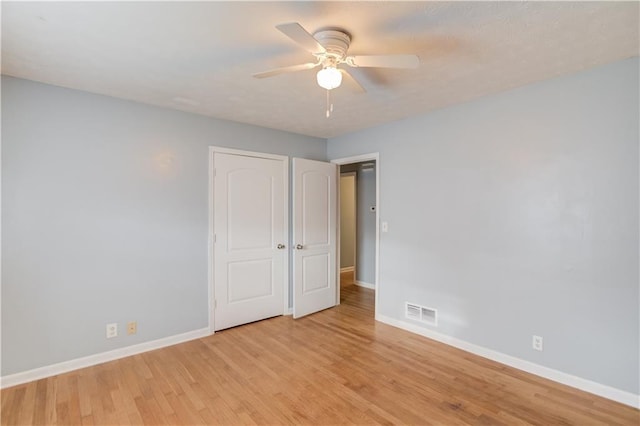 unfurnished bedroom with ceiling fan, light wood-type flooring, visible vents, and baseboards