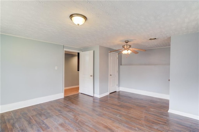 unfurnished room with visible vents, wood finished floors, a ceiling fan, and baseboards