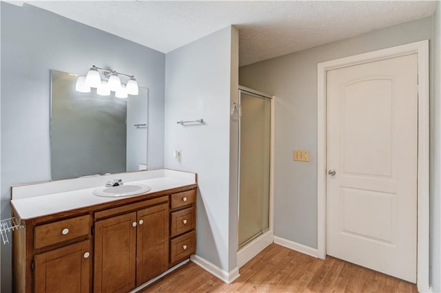 full bath with wood finished floors, vanity, and a shower stall