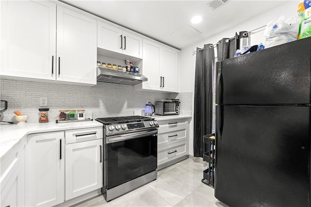 kitchen featuring backsplash, black fridge, stainless steel range, wall chimney range hood, and white cabinetry