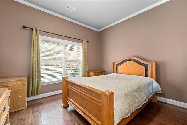 bedroom featuring dark hardwood / wood-style floors and ornamental molding