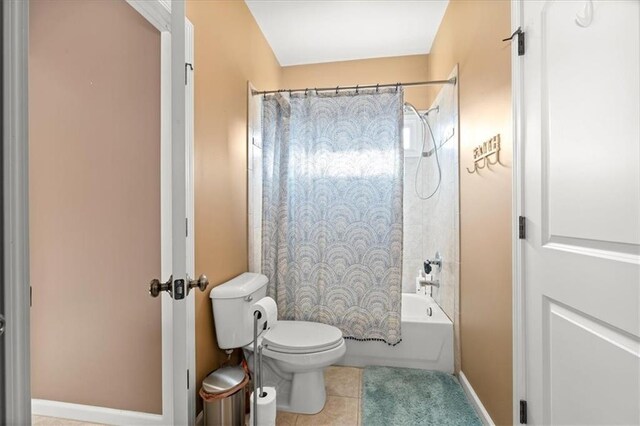 bathroom with toilet, tile patterned floors, and shower / bath combo with shower curtain