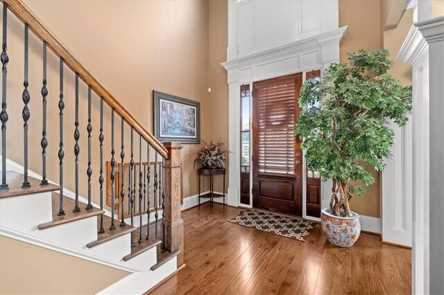 foyer featuring a towering ceiling and hardwood / wood-style flooring