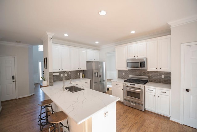 2019 Chelton Way SE, Smyrna, GA 30080 - kitchen featuring crown molding, a kitchen breakfast bar, a sink, stainless steel appliances, and a peninsula