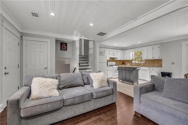 living room featuring crown molding, dark hardwood / wood-style floors, and sink