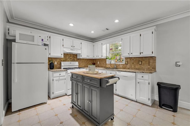 kitchen featuring white cabinets, a kitchen island, ornamental molding, sink, and white appliances