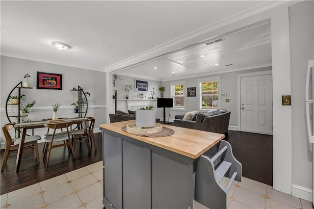 kitchen featuring ornamental molding, a center island, and light hardwood / wood-style flooring