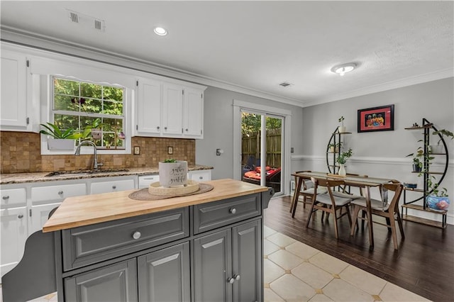 kitchen with white cabinetry, sink, hardwood / wood-style floors, and a wealth of natural light