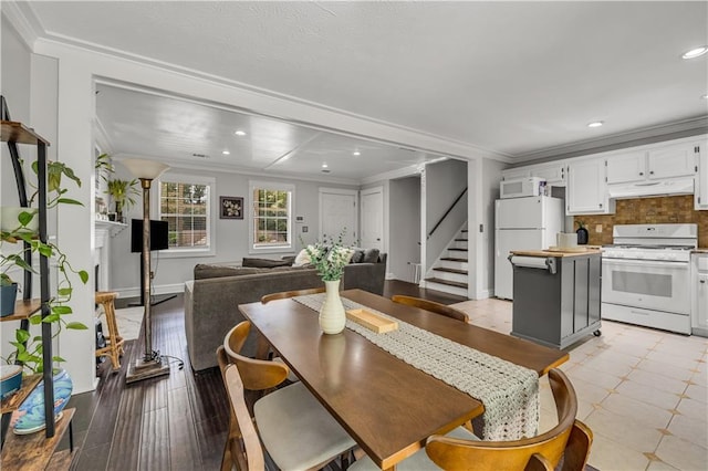 dining area with light hardwood / wood-style flooring and ornamental molding