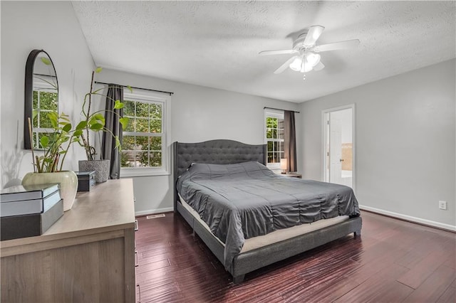 bedroom with dark hardwood / wood-style floors, ensuite bathroom, a textured ceiling, and ceiling fan