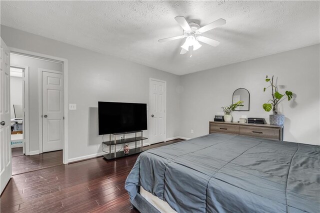 bedroom featuring ceiling fan, a textured ceiling, and dark hardwood / wood-style floors