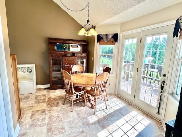 19 Magnolia Ct NE, Rydal, GA 30171 - dining space with a chandelier, vaulted ceiling, a textured ceiling, and baseboards