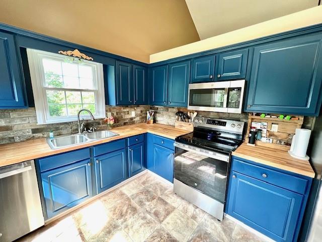 19 Magnolia Ct NE, Rydal, GA 30171 - kitchen with appliances with stainless steel finishes, blue cabinetry, a sink, and vaulted ceiling