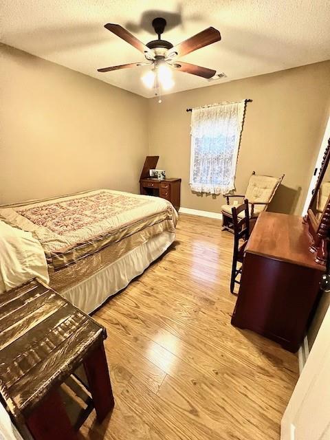19 Magnolia Ct NE, Rydal, GA 30171 - bedroom with light wood finished floors, a textured ceiling, ceiling fan, and baseboards