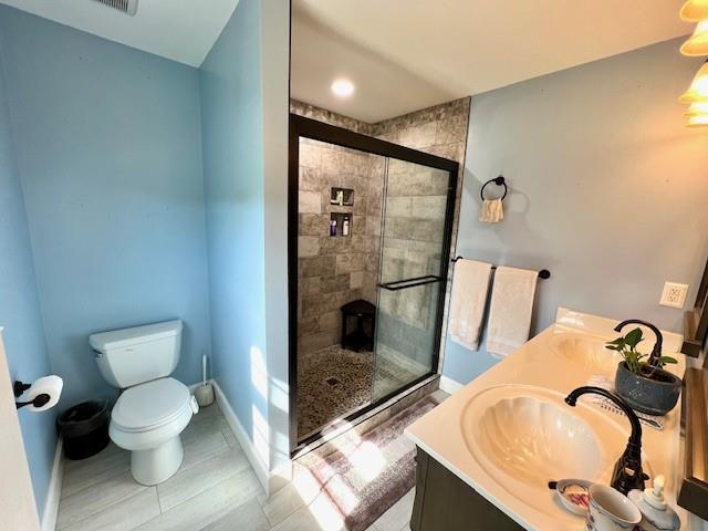 19 Magnolia Ct NE, Rydal, GA 30171 - bathroom with a stall shower, toilet, baseboards, and double vanity