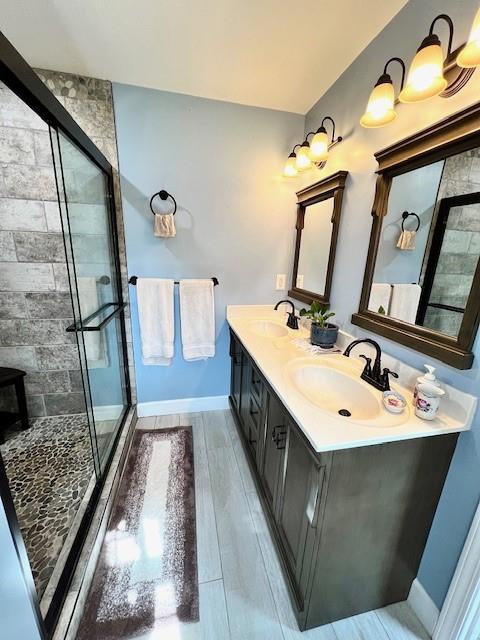 19 Magnolia Ct NE, Rydal, GA 30171 - bathroom with a stall shower, baseboards, double vanity, and wood finished floors