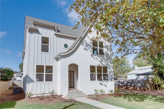 3395 Lee St, East Point, GA 30344 - view of front facade featuring central AC unit, fence, a shingled roof, board and batten siding, and brick siding