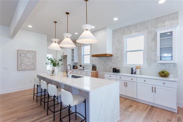 3395 Lee St, East Point, GA 30344 - kitchen featuring a sink, decorative backsplash, a kitchen breakfast bar, and light wood-style floors