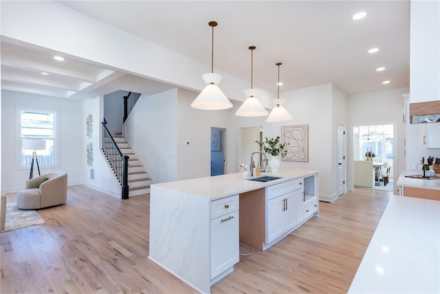 3395 Lee St, East Point, GA 30344 - kitchen featuring an island with sink, recessed lighting, a sink, white cabinets, and light wood-type flooring