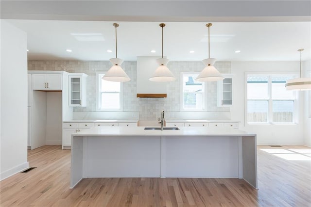 3395 Lee St, East Point, GA 30344 - kitchen featuring light countertops, light wood-style floors, a center island with sink, and a sink