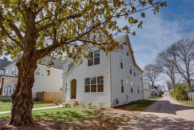 view of front facade featuring fence, board and batten siding, a front yard, and entry steps