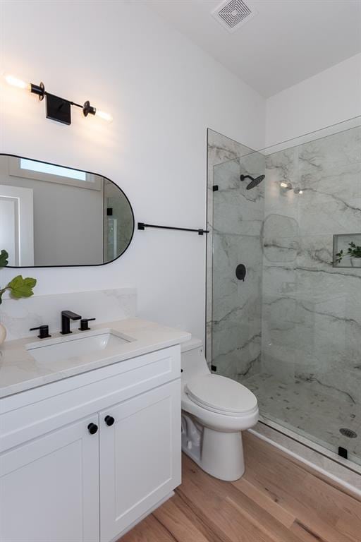 3395 Lee St, East Point, GA 30344 - full bath with vanity, wood finished floors, visible vents, a marble finish shower, and toilet