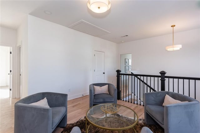 3395 Lee St, East Point, GA 30344 - sitting room with wood finished floors, visible vents, baseboards, attic access, and an upstairs landing