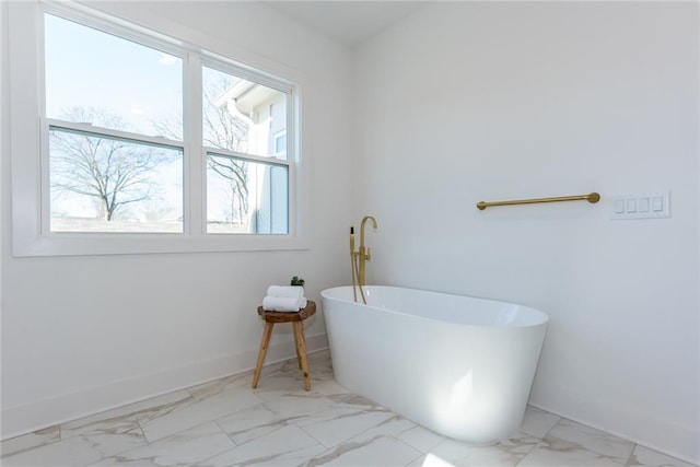 3395 Lee St, East Point, GA 30344 - bathroom featuring marble finish floor, a freestanding bath, and baseboards