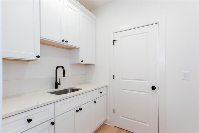 3395 Lee St, East Point, GA 30344 - kitchen with white cabinetry, light stone countertops, light wood finished floors, and a sink