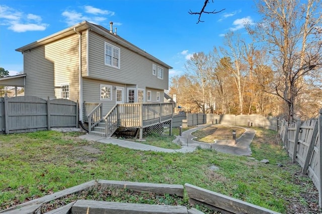 back of house featuring a wooden deck and a yard