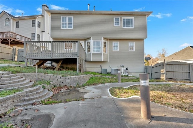 back of property with central AC unit and a deck